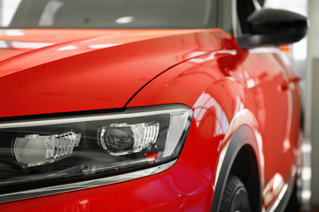 Fototapeta na wymiar New luxury car in modern auto dealership, closeup