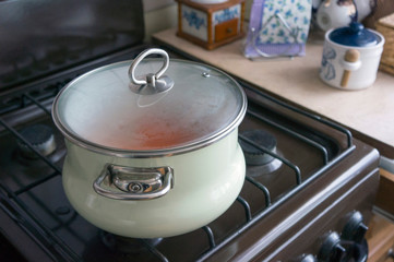 Vegetables are cooked in an enamel pot on the stove
