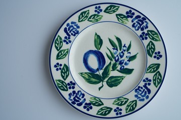 High angle shot of a big white plate with beautiful floral patterns on grey background