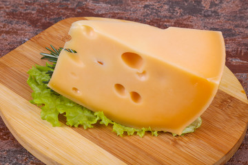 Maasdam cheese  in the board served salad leaves