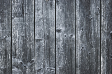 Dark gray wood fence. Shabby table. Old grey wooden boards. Pattern of cracked planks. Strips on wood surface. Dilapidated boards with nails. Grunge texture.
