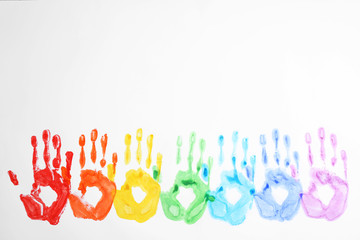 Handprints made with bright paints on white background, top view. Rainbow colors