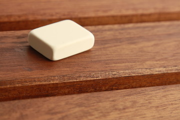 goma de borrar de color blanco sobre fondo de madera