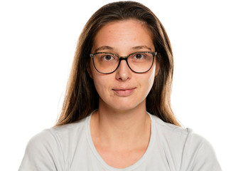 Obraz premium Portrait of young smiling woman with glasses and without makeup on white background