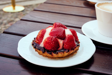 Erbeer Tarte Kuchen mit einem Kaffee auf einer Terrasse 