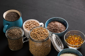 Food background. Various seeds and grains- Source of omega 3 foods. Fish oil, chickpeas, soybeans, hemp seeds, chia, sesame seeds, flax seeds. Omega 3 background.