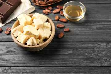 Composition with organic cocoa butter on black wooden table, above view. Space for text