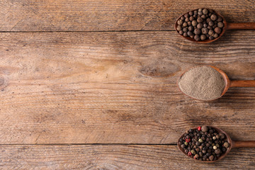 Different peppers on wooden table, flat lay. Space for text