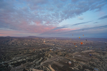 Goreme / Turkey - December 6 2019: noise and grain of mountain hill landscape in Cappadocia with hot air balloon in romantic sunrise moment