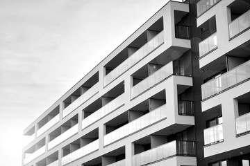 Sun rays light effects on urban buildings. Fragment of modern residential apartment with flat buildings exterior. Detail of new luxury house and home complex. Black and white.
