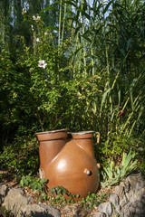 A large clay vessel for collecting water and watering plants.