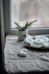 Pavlov’s round white cake on a plate on a linen tablecloth, near the window. For calendar, cover, posters.