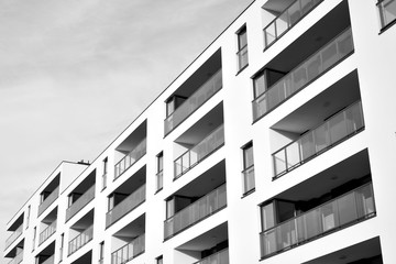 Sun rays light effects on urban buildings. Fragment of modern residential apartment with flat buildings exterior. Detail of new luxury house and home complex. Black and white.