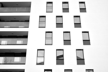 Sun rays light effects on urban buildings. Fragment of modern residential apartment with flat buildings exterior. Detail of new luxury house and home complex. Black and white.