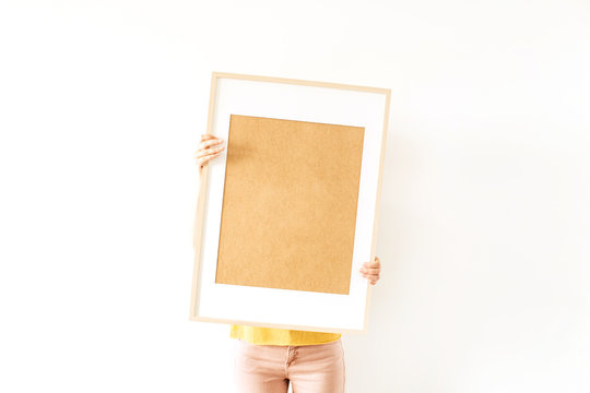Young pretty woman hold blank photo frame with empty mockup copy space. Minimal art concept.