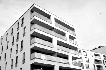 Sun rays light effects on urban buildings. Fragment of modern residential apartment with flat buildings exterior. Detail of new luxury house and home complex. Black and white.