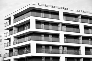 Sun rays light effects on urban buildings. Fragment of modern residential apartment with flat buildings exterior. Detail of new luxury house and home complex. Black and white.