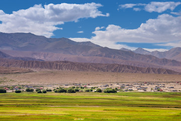 Mountain ranges,desert,pasture,village and cloudscape