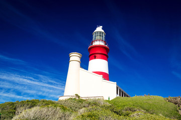 Fototapeta na wymiar The red and white lighthouse at Cape Agulhas on a sunny day with clear blue sky, South Africa