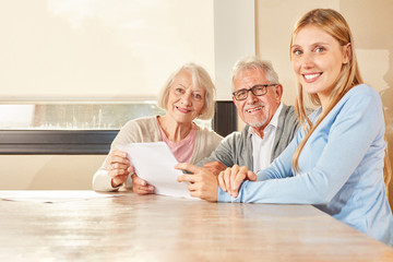 Daughter and seniors with contract of insurance