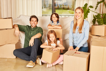 Family with two children between moving boxes
