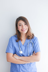Asian woman in blue doctor uniform using telephone on white background