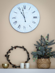Decorating living room with natural materials - wreath made from larch branches  and some fir tree branches put in a basket. Watch hanging on a wall