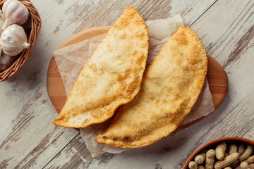 Georgian dish on the table photo for the menu of Eastern Caucasian cuisine. Cheburek flat lay.