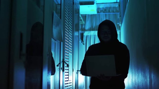 A computer programmer or hacker prints a code on a laptop keyboard to break into a secret organization system.