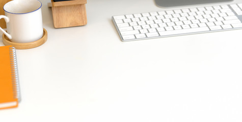 Close-up view of modern office room with keyboard computer and office supplies on white table