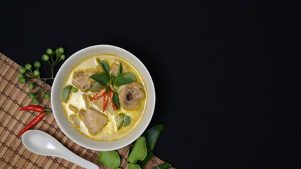 Thai cuisine concept : chicken green curry and ingredients on black desk background