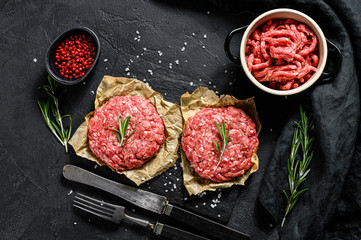 Fototapeta na wymiar Raw Ground beef meat Burger steak cutlets and seasonings. Farm organic meat. Black background. Top view