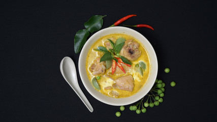 Top view of chicken green curry and ingredients on black desk background