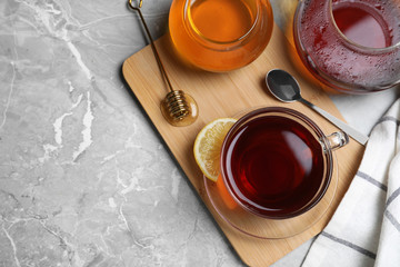Obraz na płótnie Canvas Flat lay composition of tea with honey on light grey marble table. Space for text