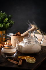 Milk spicy Indian tea Masala in a teapot with cinnamon, cloves and anise. Oriental tea ceremony on...
