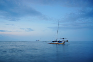 Fototapeta premium Traditional fishing vessels that still use traditional fishing gear, this boat is made of wood that is resistant to sea water. Fishing boats dock at the seashore.