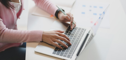 Close-up view of young businesswoman working on her project with laptop computer