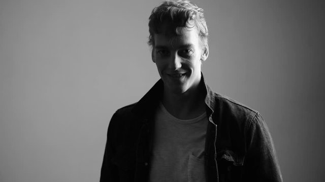 Face of happy young handsome man smiling in black and white