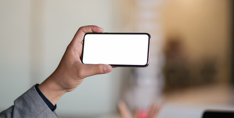 Cropped shot of professional businessman showing blank screen smartphone
