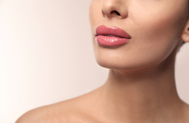 Obraz na płótnie Canvas Woman with pink lipstick on light background, closeup