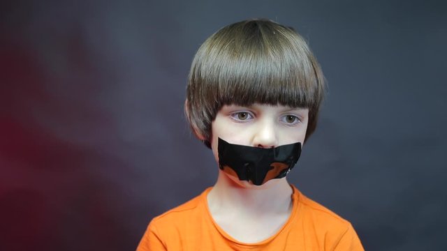 Portrait of a schoolboy with a black ribbon on his face. 