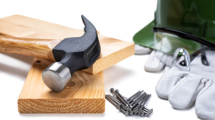 Close-up of a carpenter's hammer, helmet and leather protective gloves on a white background. Industry construction, work safety. 