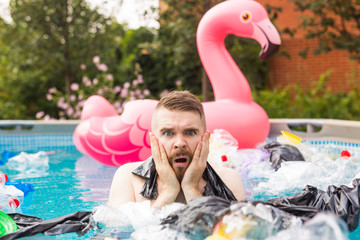 Ecology, plastic trash, environmental emergency and water pollution - shocked man swim in a dirty...