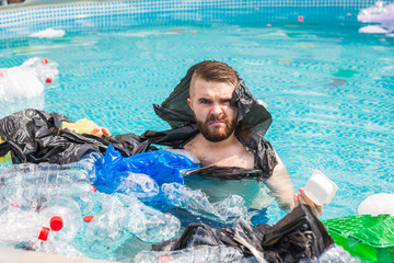 Ecology, plastic trash, environmental emergency and water pollution - shocked man swim in a dirty swimming pool