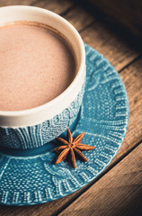 Cup of hot chocolate in winter decorations on the rustic background. Selective focus. Shallow depth of field.