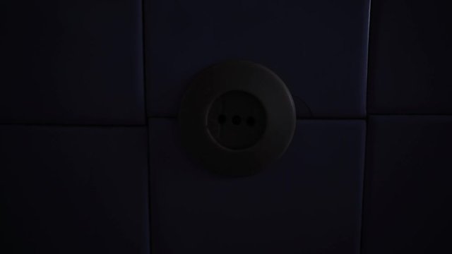 Old socket on the wall. Short circuit. Old power grid. Voltage drop in the room. The light is blinking. Danger. Lighting turn on and off. Power source. House of Horror.