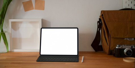 Close-up view of professional photographer workplace with blank screen tablet and office supplies