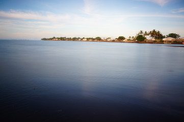 the atmosphere of the beach or the coast before the afternoon with calm waves and sunny weather set against the background of the high seas and mountains or plateaus