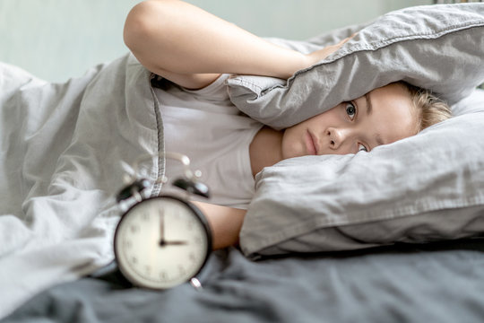 Woman with insomnia lying in bed with open eyes. Early morning hours. Insomnia and sleep problems. Relax and sleep concept. Feels sleepy and tired. Early to get up. Relax and sleep concept.