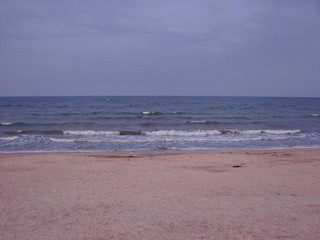 Panorama of the stormy water surface of the Sea of ​​Azov, which connects on a boundless horizon with a cloudy evening sky.